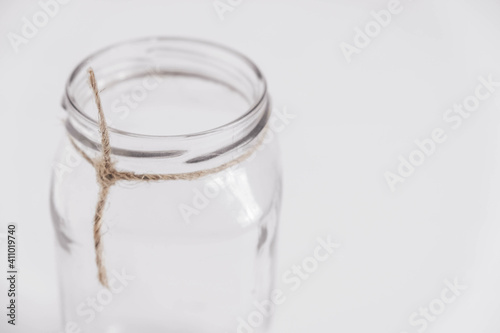 Glass transparent jar on a white table background. Copy, empty space for text