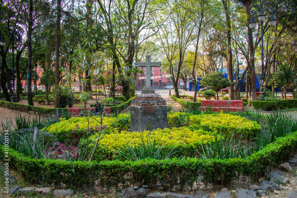 Stone cross in the middle of a park from Coyoacan