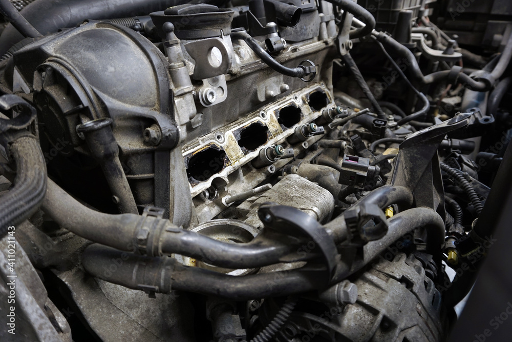 A partially disassembled engine of a modern car is ready for repair. The engine is dirty. Car service, spare parts. A partially disassembled engine of a modern car is ready for repair. The engine is dirty. Car service, spare parts.