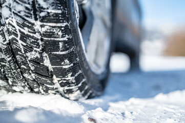 Winter tire. Detail of car tires in winter on the road covered with snow.