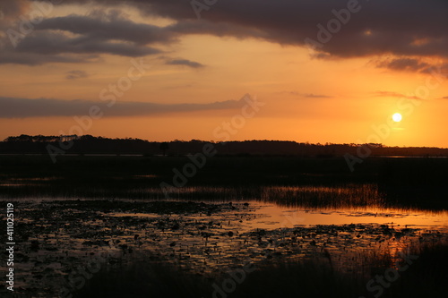 Reflection of orange and blue sky over the lake during sunset in Florida. 