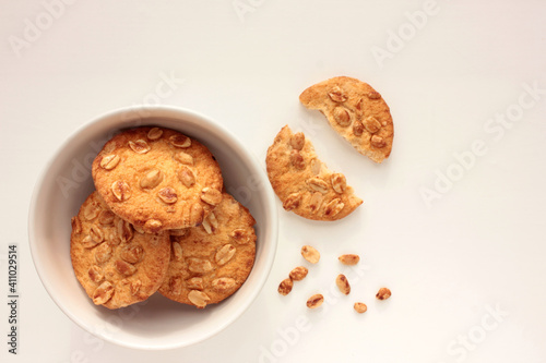 Peanut cookies in a bowl on table. Overhead view of homemade pastry on white background with copy space