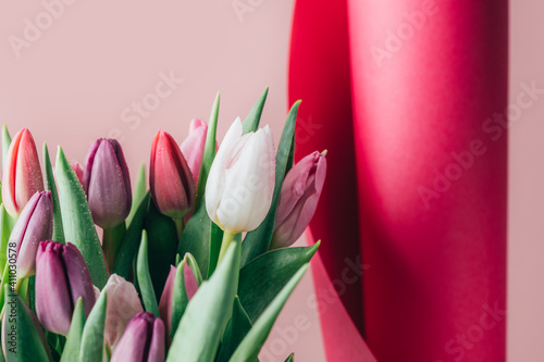 Fototapeta Naklejka Na Ścianę i Meble -  Beautiful Bunch of Colorful Classic Tulips in the Vase on pink background, spring holiday concept