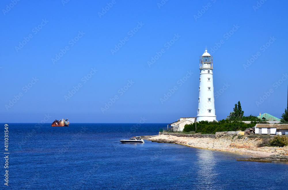 Landscape, white lighthouse on the shore of the sea, sunken, stranded ship, a rusty ship near the lighthouse