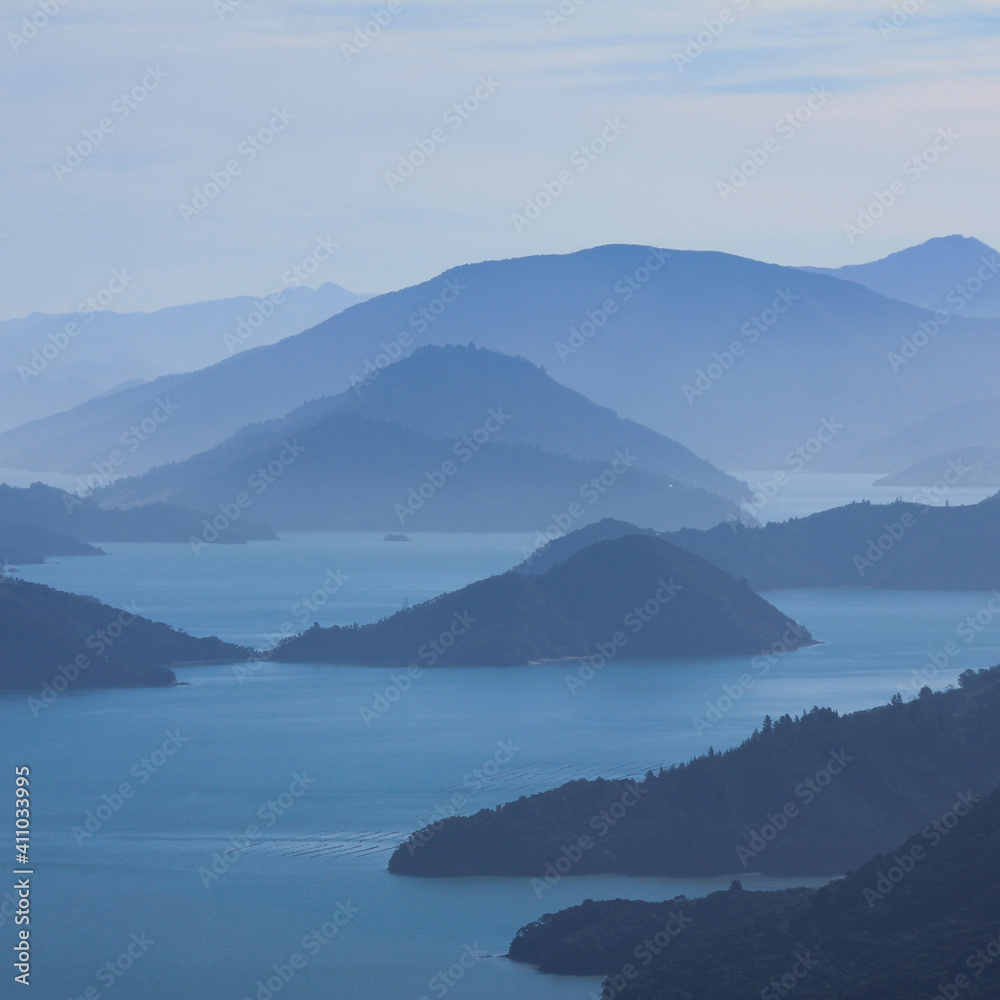Outlines of hills and bay on a hazy day in New Zealand.