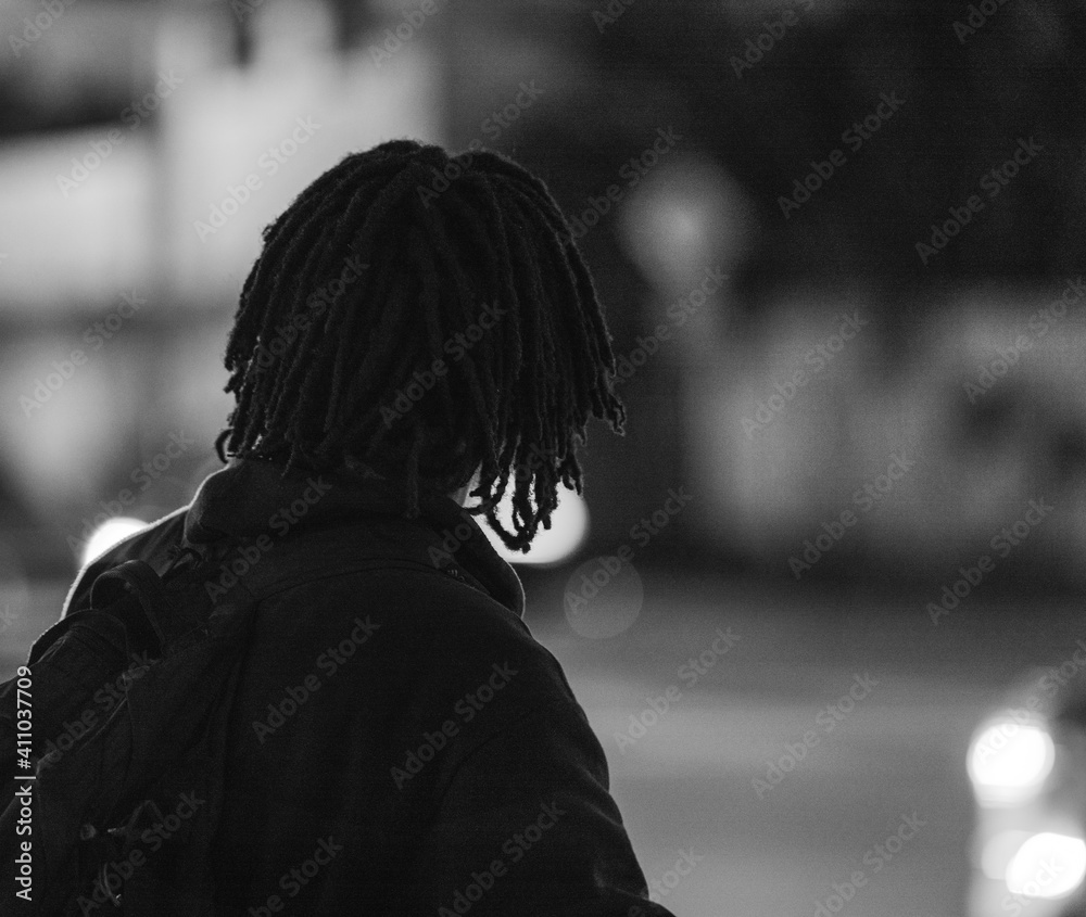 silhouette of a person unrecognizable black man hair back street night 