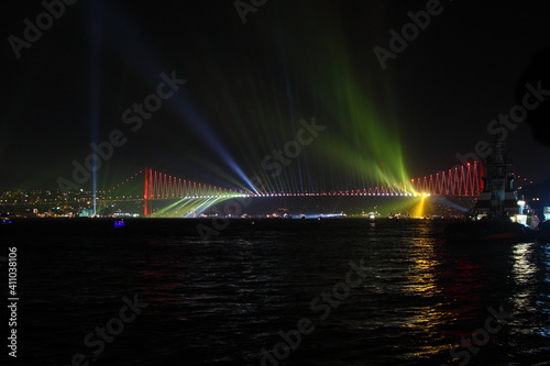 Fireworks over Istanbul Bosphorus during Turkish Republic Day celebrations. Bosphorus Bridge with red lighting and lasers at night time.