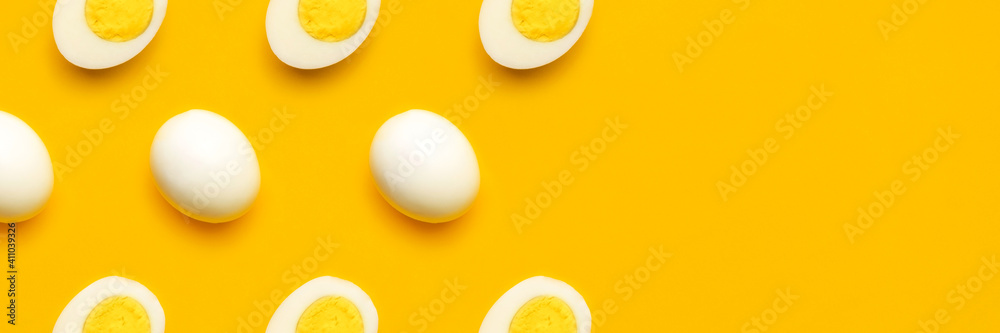 Banner with fresh chicken boiled half cut eggs pattern on yellow background. Healthy food or Happy Easter creative minimal concept. Flat lay, top view