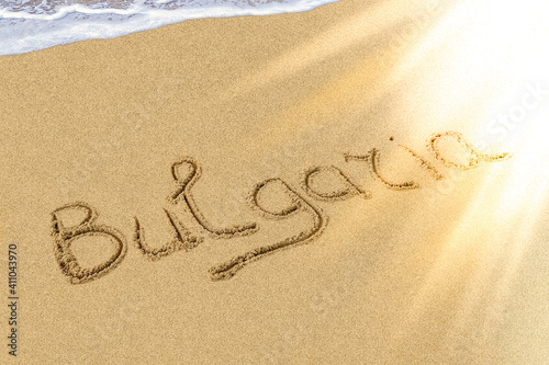 Bulgaria title on the light sand beach near the black sea coast. Brilliant sun ray falls on the letters.