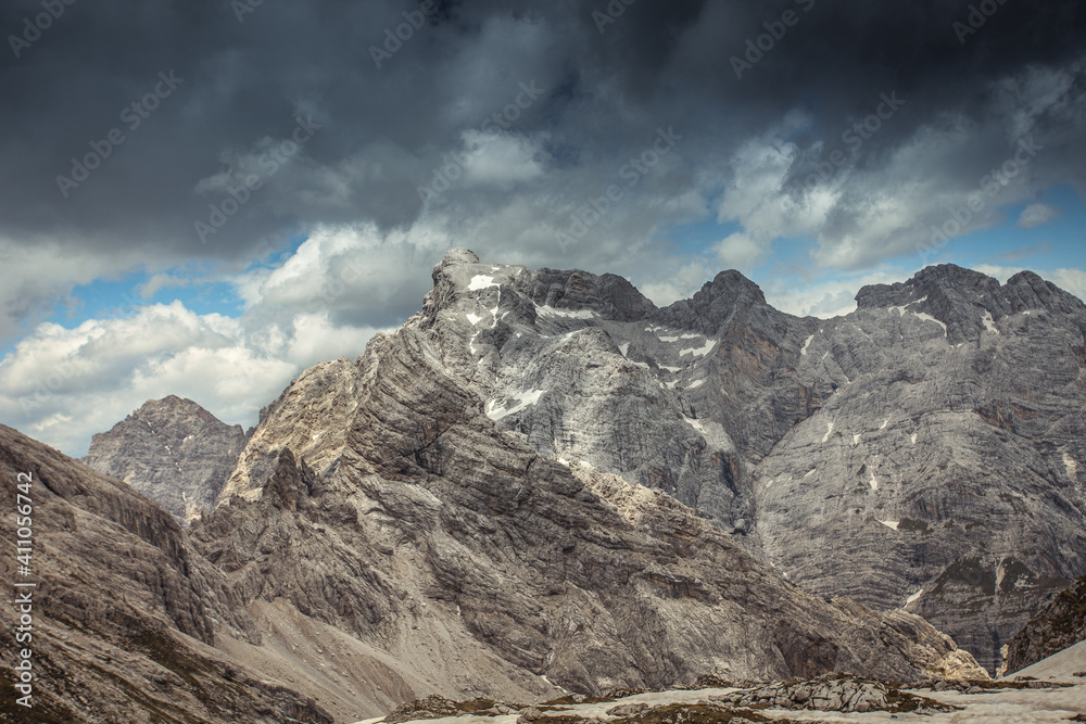 Panorama of the rocky scenario of Cima dei Preti mountain range with dramatic cloudy sky, Dolomites, Italy
