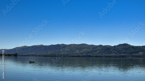 bote pesquero en lago san roque , pescando con caña en un hermoso espejo de agua en la ciudad de villa carlos paz cordoba argentina