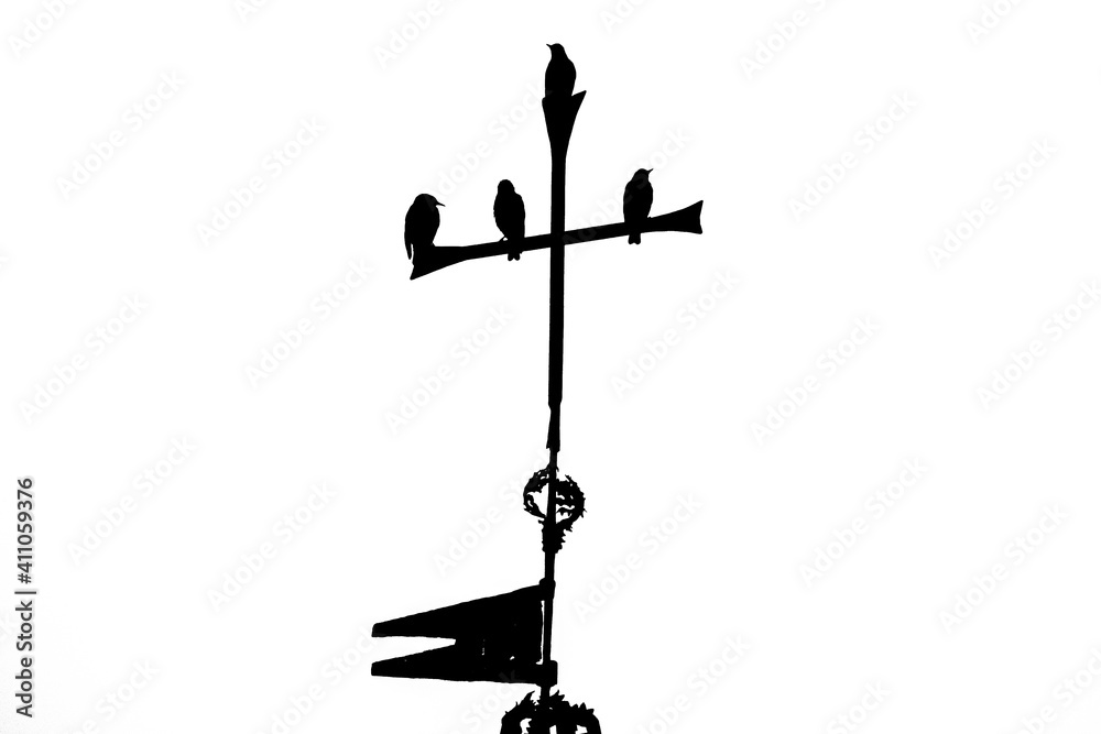 bird silhouette on top of an iron cross bird silhouette on top of an iron cross