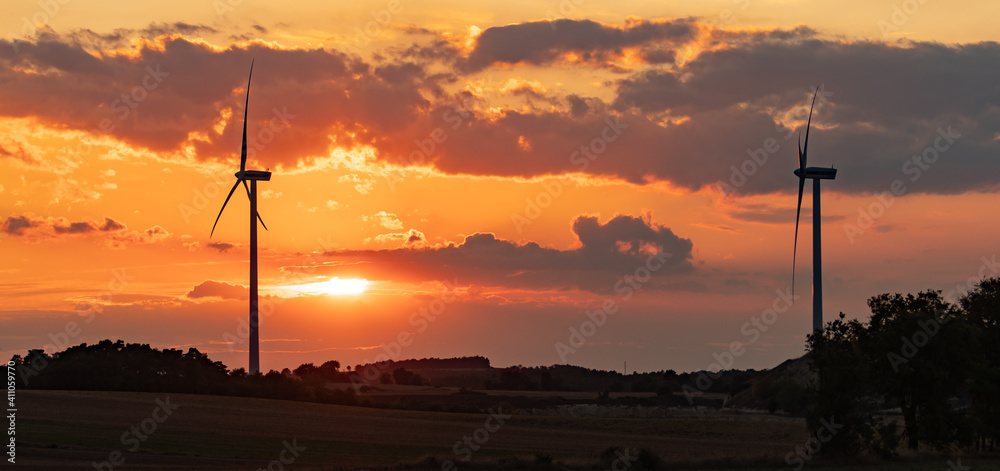 Obraz premium wind turbines during sunset under partly cloudy skies