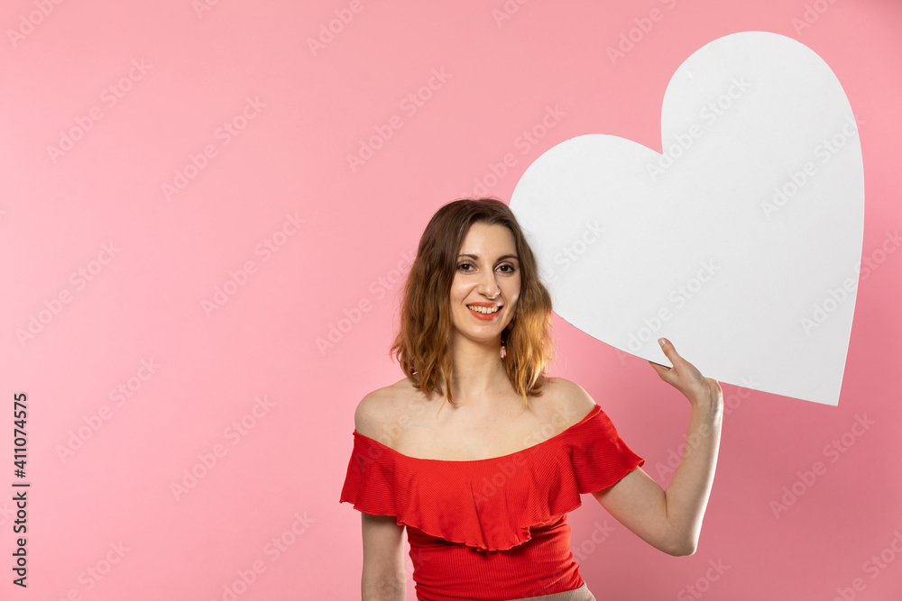 Girl with a large white heart shape in the hands. A student in love stands and holds a large heart shape in her hands. Valentine's Day and love. Girl with a large white heart shape in the hands. A student in love stands and holds a large heart shape in her hands. Valentine's Day and love.