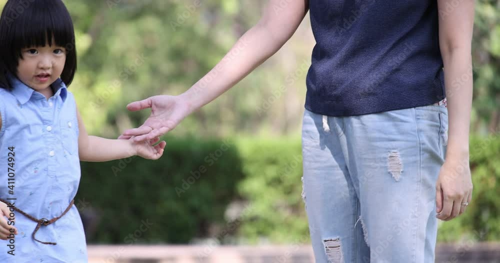 4K Video Slow motion Asian mom and little daughter hold hand walking in the park. Concept for family relationship and relaxing time. 4K Video Slow motion Asian mom and little daughter hold hand walking in the park. Concept for family relationship and relaxing time.