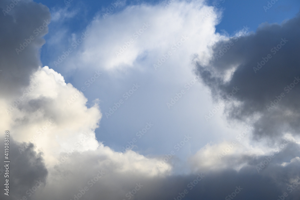 Dramatic and glowing cloudscape of blue sky and white and gray clouds as a nature background
