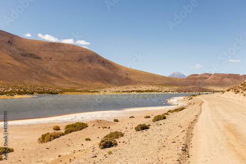 Desert road with lake and mountain