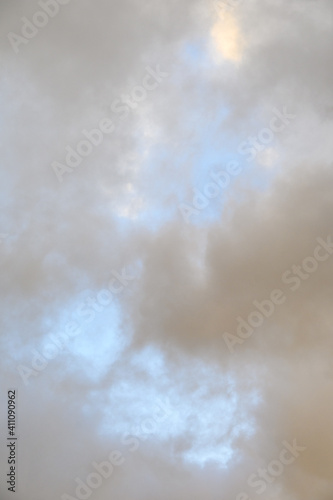 Pastel and moody glowing cloudscape, sun highlighted clouds and pale blue sky, as a nature background 