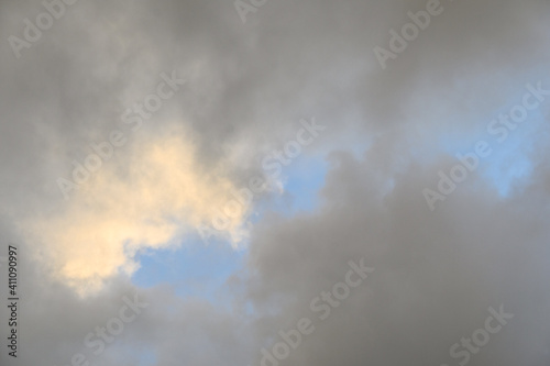 Pastel and moody glowing cloudscape, sun highlighted clouds and pale blue sky, as a nature background © knelson20