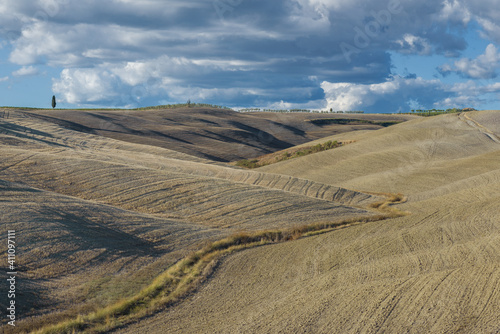 Harvested hilly fields under a September cloudy sky. Tuscany, Italy