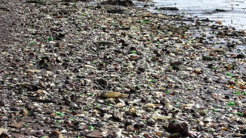 Extremely polluted Beach on Atlantic Ocean. Trash, Rubbish and waste covering sand on beach. Glass peaces polluting beautiful Beach. Recycle failure