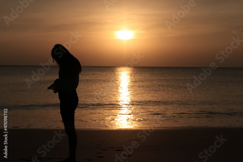 Free young woman raising arms to golden sunset. Freedom and success concept,relaxing and enjoying nature