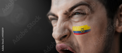 A screaming man with the image of the Ecuador national flag on his face