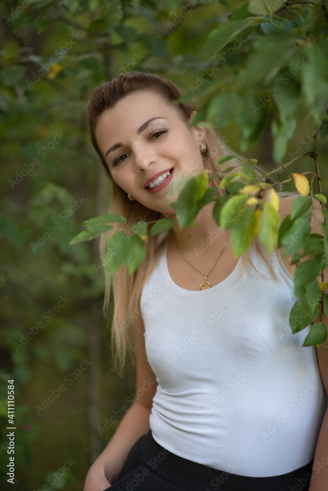 Portrait of a beautiful blonde girl with a wide smile in the park. Portrait of a beautiful blonde girl with a wide smile in the park.