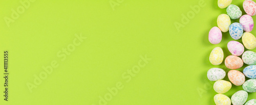 Flat lay composition of Happy Easter holiday concept. Colorful pastel egg on green background. top view, copyspace, banner