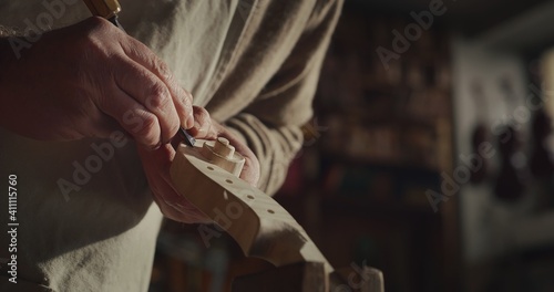 Canvastavla Cinematic shot of experienced master artisan luthier painstaking detail work on fine quality wood violin in creative workshop