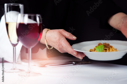 Kellnerin / Bedienung serviert einen Teller Essen in einem Restaurant