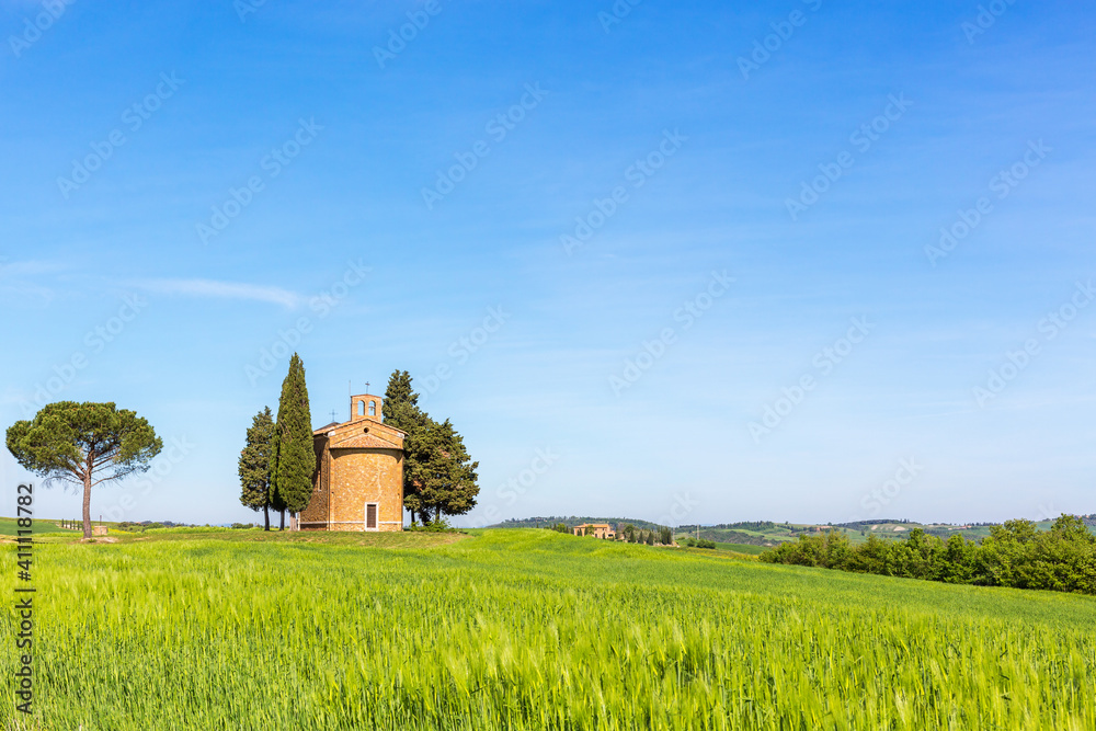 View of a cornfield with an old chapel in the rural landscape
