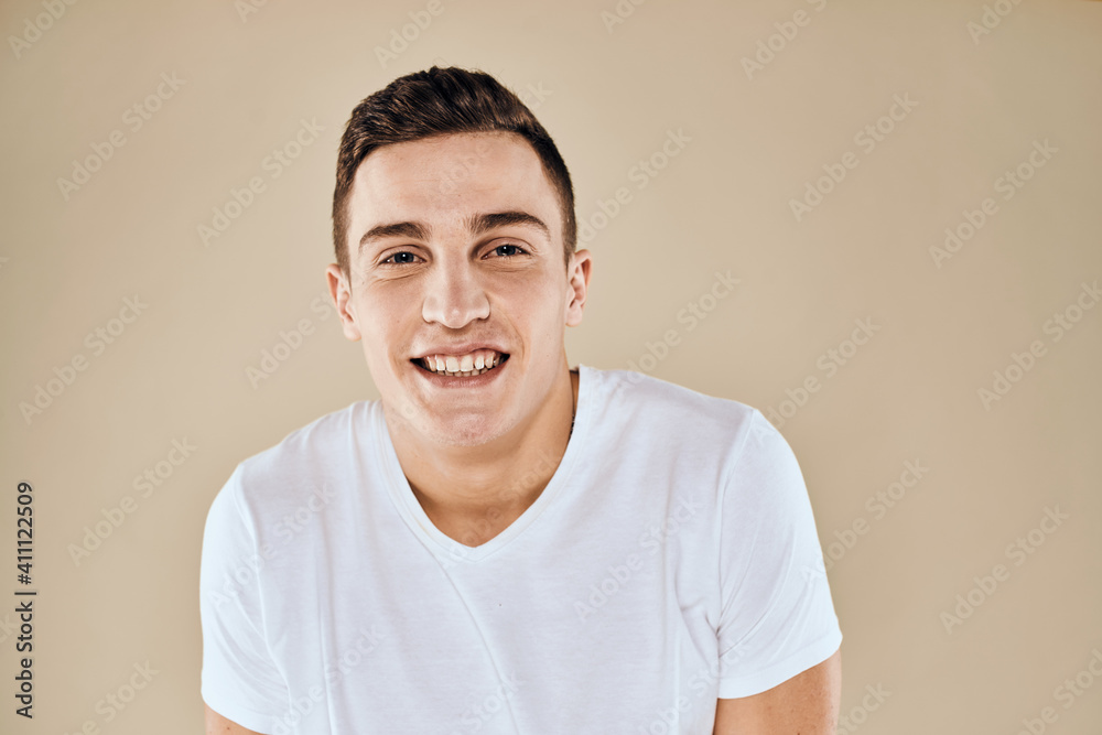 Cute emotional man white t-shirt gesture with hands cropped view beige studio background