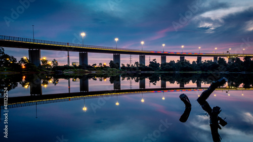 The reflections of the melbourne city skyline at dusk in the still water of the west gate bridge