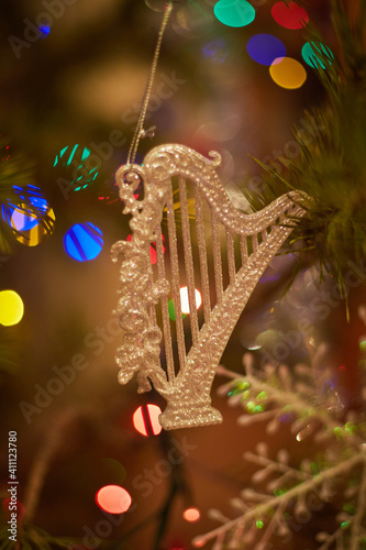 Christmas Tree Harp Decoration close-up with multi-color lights in the background