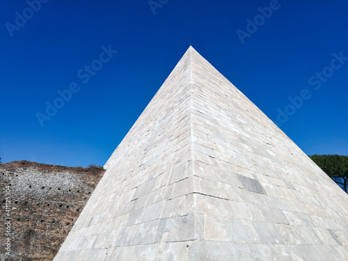 White marble of ancient Pyramide Cestia in blue sky background the famous sepulcher building at 12 A.C. houses the tomb of Gaio Cestio Epulone its located in Rome