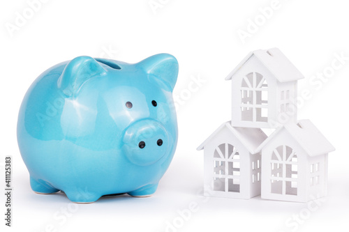 Savings for buying a house. Piggy bank and house on white background