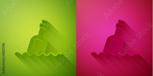 Paper cut Glass bottle with a message in water icon isolated on green and pink background. Letter in the bottle. Pirates symbol. Paper art style. Vector.