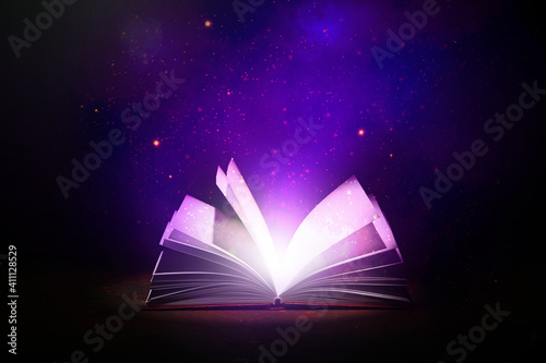 Open magic book on dark bac...