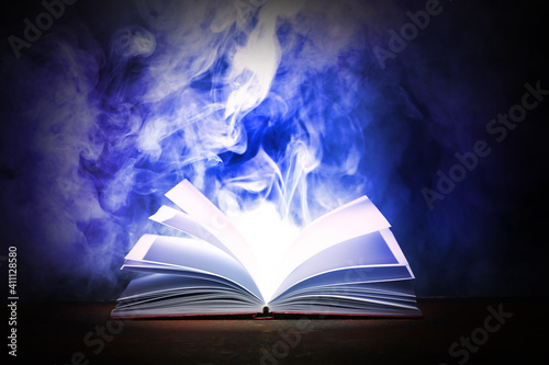 Open magic book on dark bac...