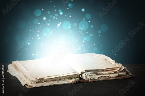 Open magic book on dark background