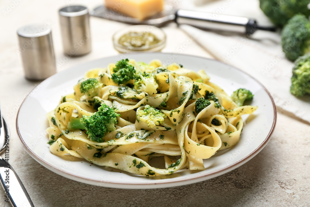 Plate with delicious pasta and broccoli on light background, closeup