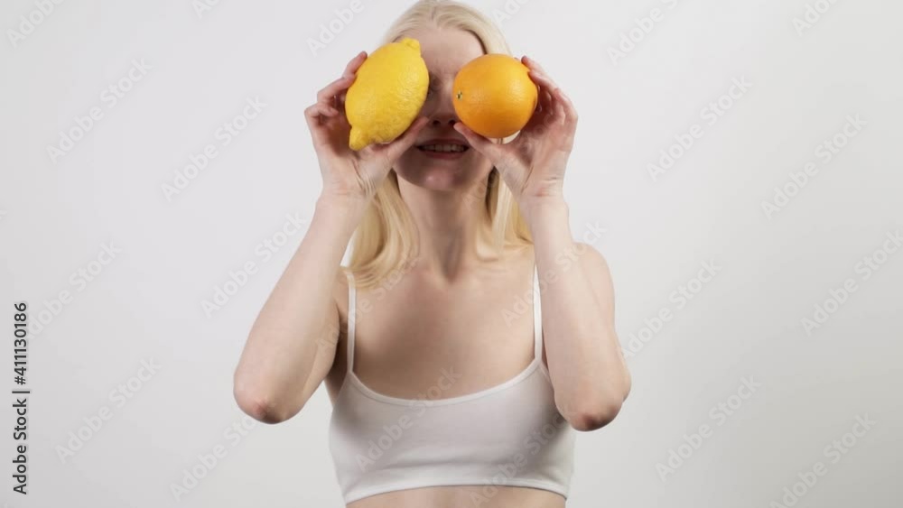 Attractive woman dancing with fresh orange and lemon, happy to spend time at home Attractive woman dancing with fresh orange and lemon, happy to spend time at home