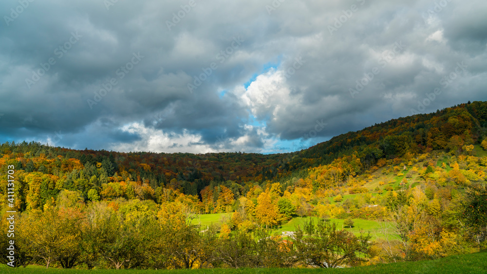 Germany, Beautiful colorful autumn mood in nature landscape of swabian forest near rudersberg with sun and shadows moving above the trees
