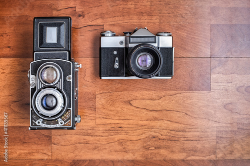 an old medium format twin lens reflex camera and an old 35mm reflex camera, seen from above horizontal format with copy space photo