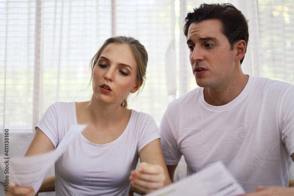Unhappy young couple feeling worried about the cost for credit card bills at home. Unhappy young couple feeling worried about the cost for credit card bills at home.