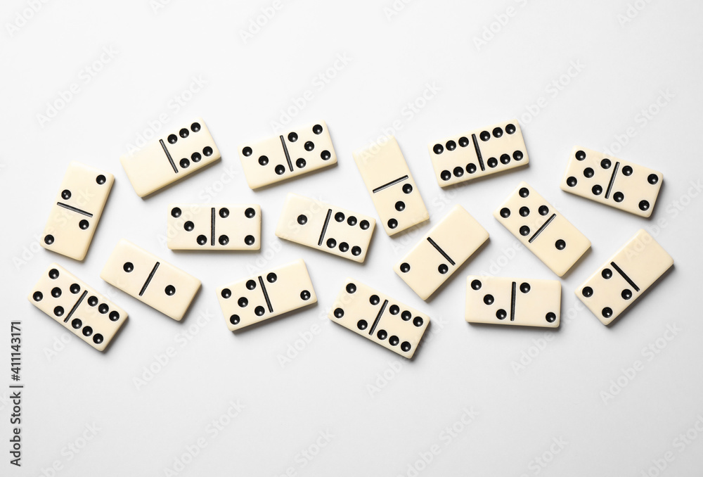Classic domino tiles on white background, flat lay Classic domino tiles on white background, flat lay