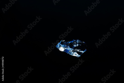 A shard of ice on a dark background of a frozen river. Flat lay of the frame. Copy space