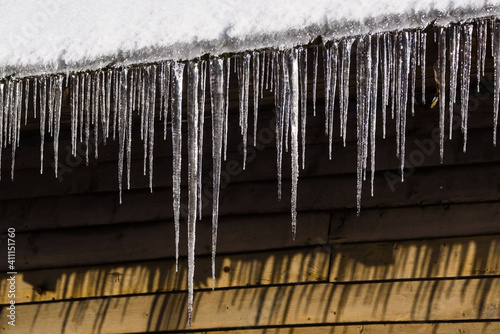 Selective focus photo. Icicle on the snow covered rooftop.