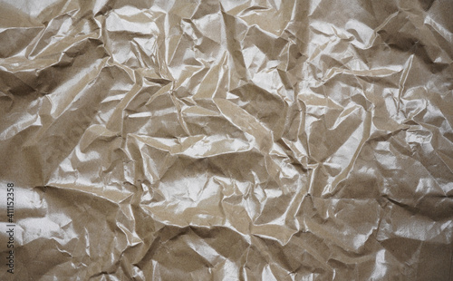 Crumpled brown paper showing pattern on shiny surface.  Backgrounds, textures, object categories.